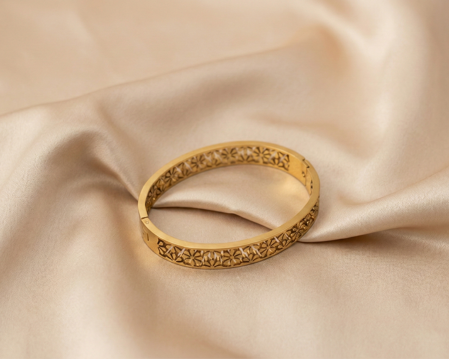 Gold bracelet on beige fabric
