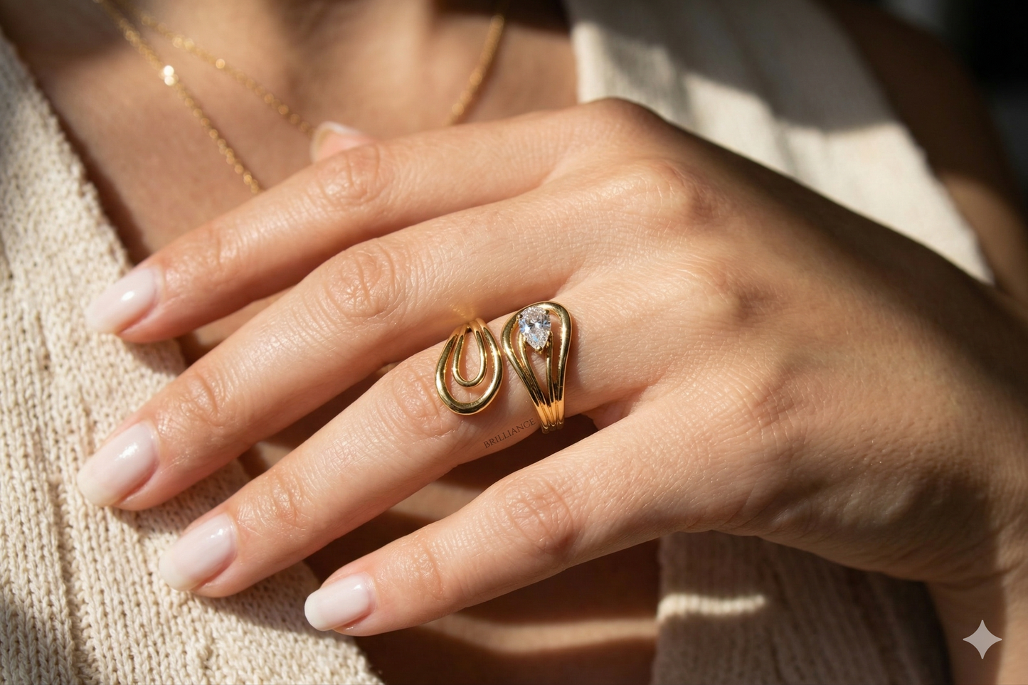 Close-up of a hand wearing two gold rings with a soft background
