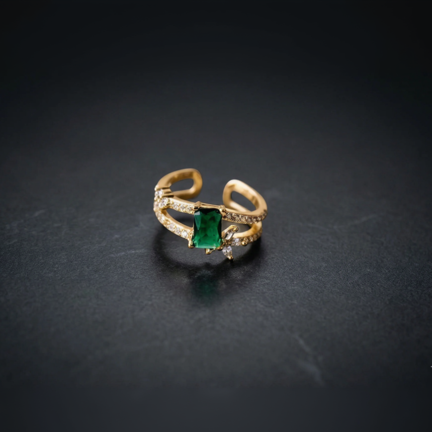 Gold ring with a green gemstone on a dark background