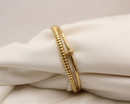 Gold bracelet on a white fabric background