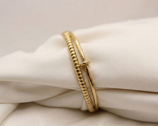 Gold bracelet on a white fabric background