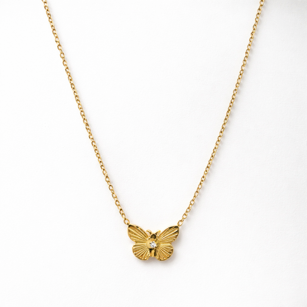 Gold butterfly necklace on a white background
