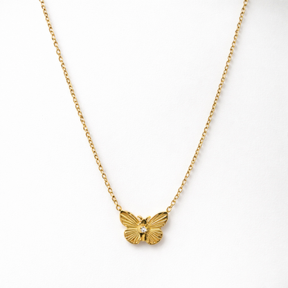 Gold butterfly necklace on a white background