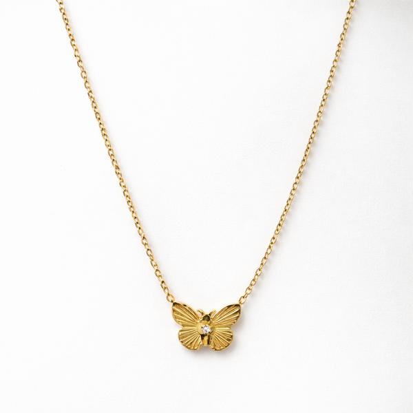 Gold butterfly necklace on a white background