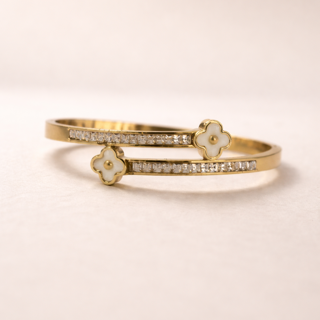 Gold bracelet with floral designs on a beige background