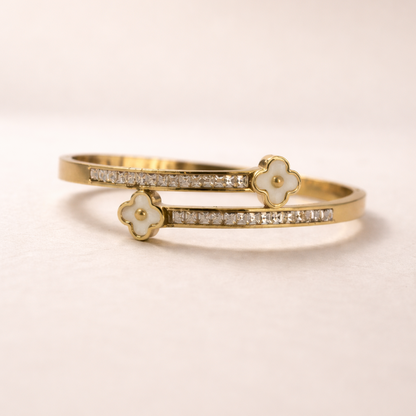 Gold bracelet with floral designs on a beige background