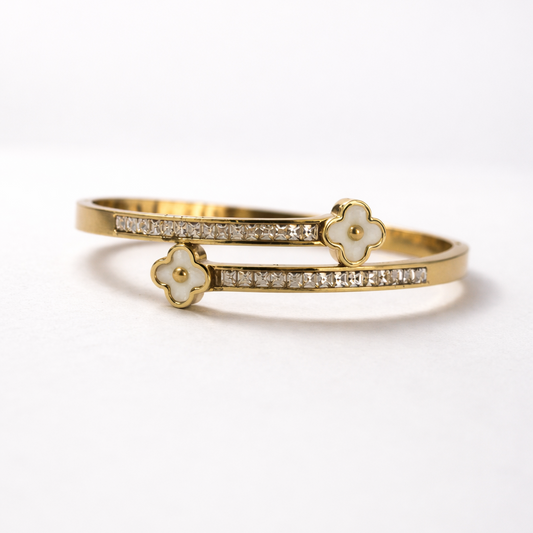 Gold bracelet with floral designs on a white background