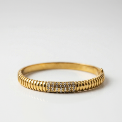Gold bracelet with rhinestones on a white background