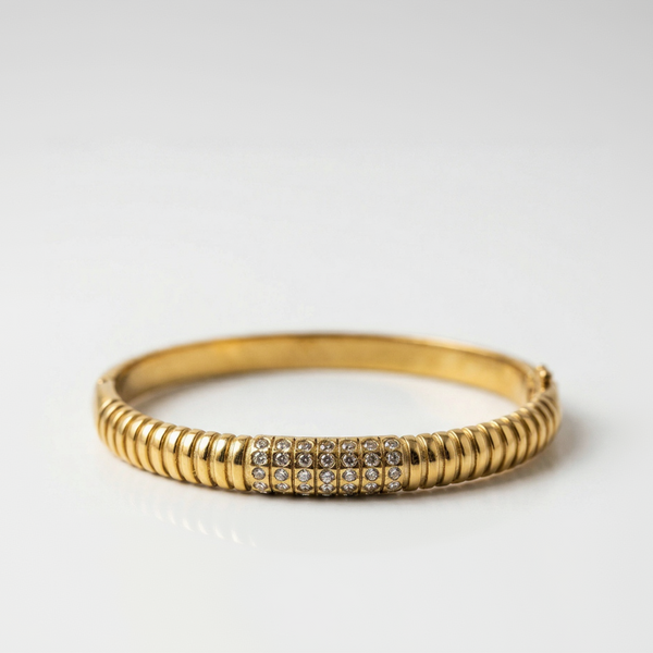 Gold bracelet with rhinestones on a white background