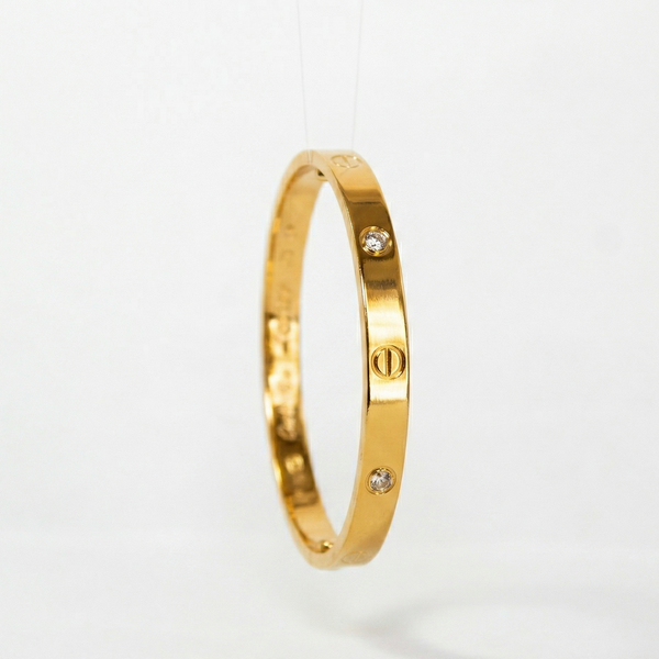 Gold bracelet with small diamonds on a light gray background