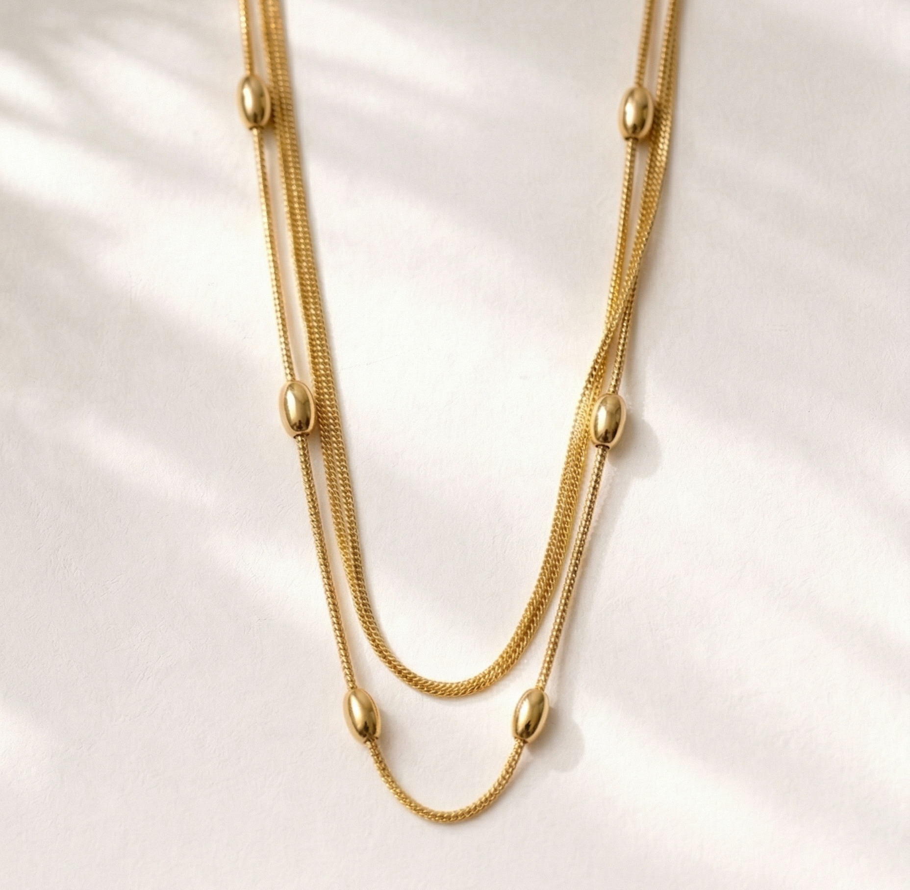 Gold necklace on a white shell background