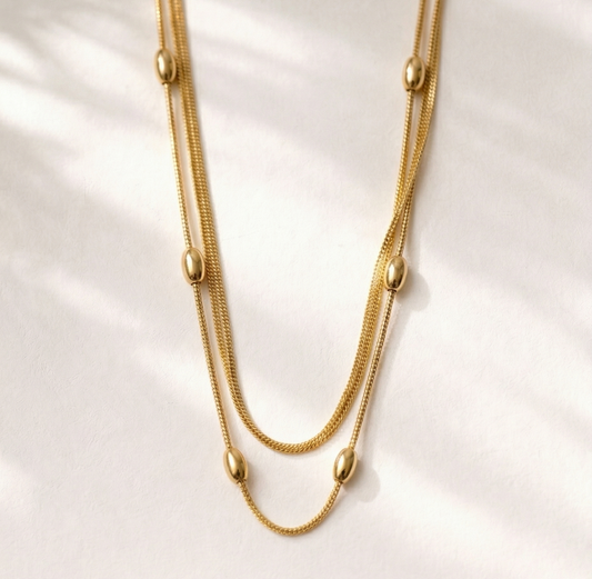 Gold necklace on a white shell background
