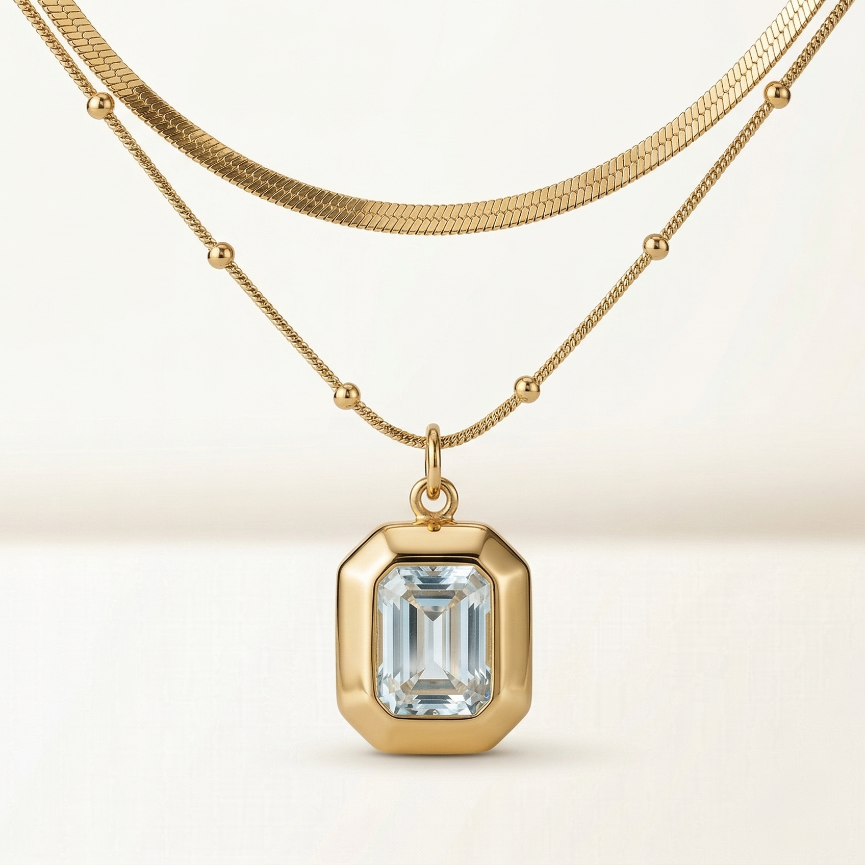 Gold necklace with a diamond pendant on a beige background