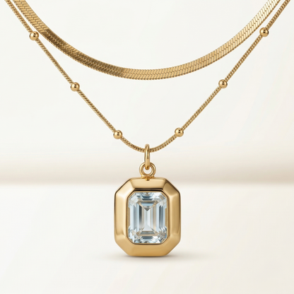 Gold necklace with a diamond pendant on a beige background
