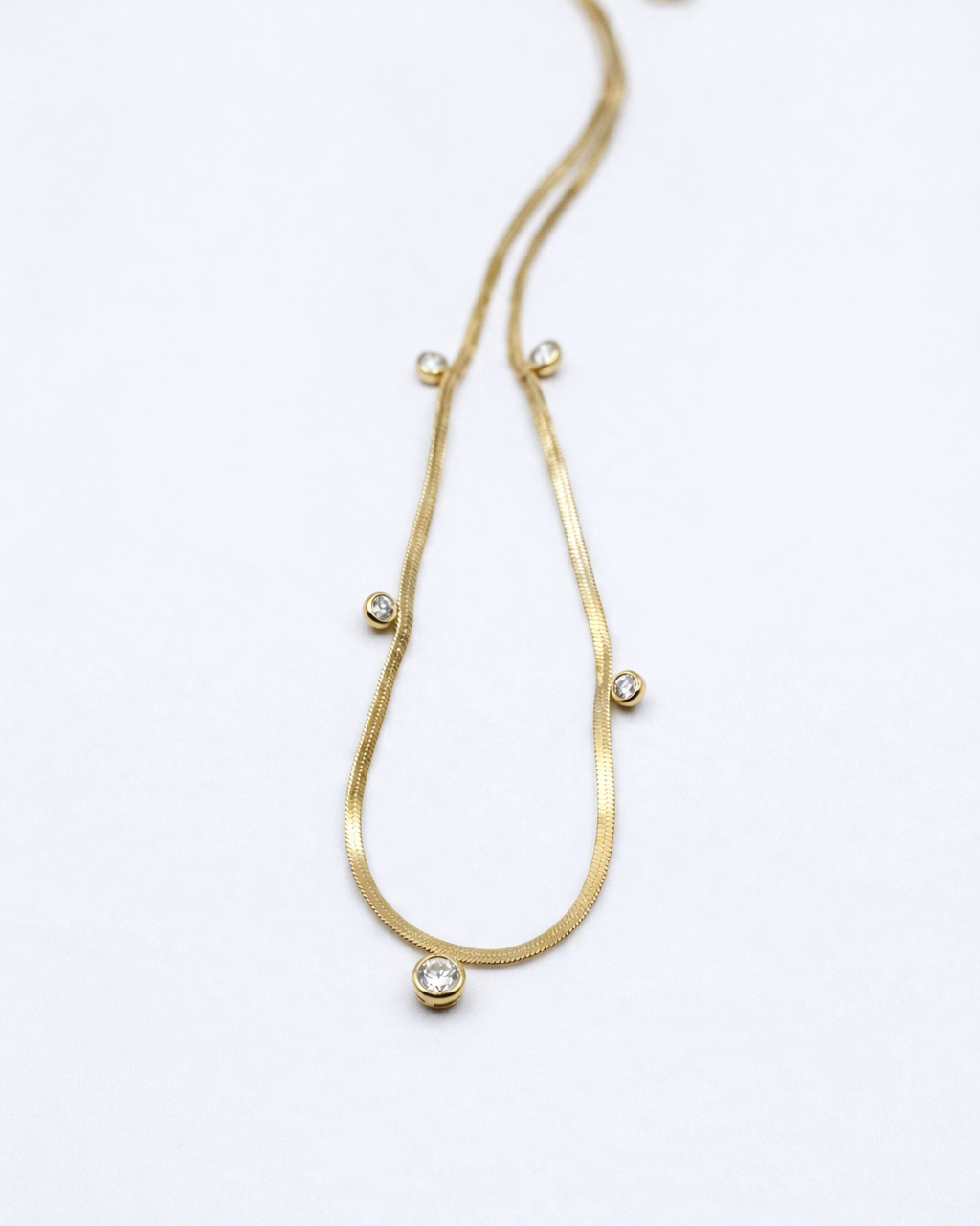 Gold necklace with small beads on a white background