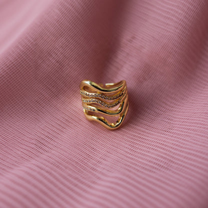 Gold ring with diamond accents on a PINK background