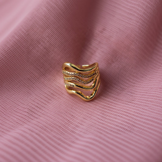 Gold ring with diamond accents on a PINK background