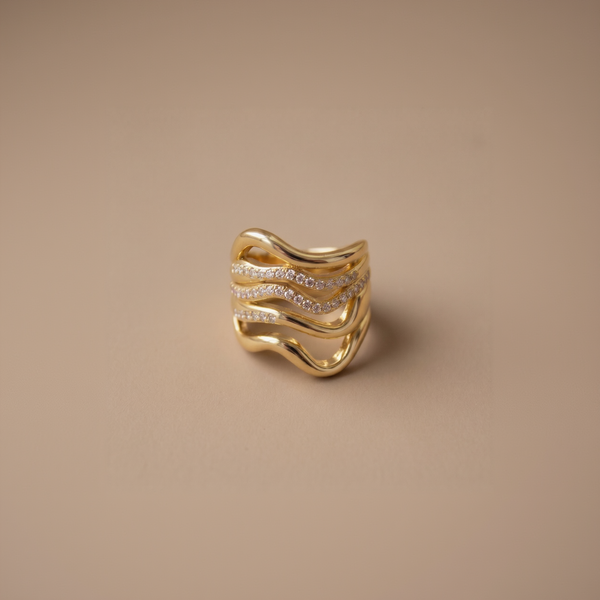 Gold ring with diamond accents on a beige background