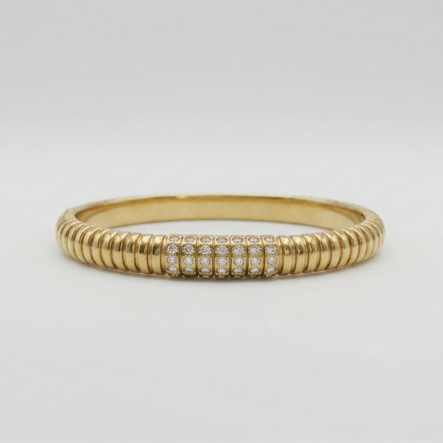 Gold ring with embedded diamonds on a light gray background