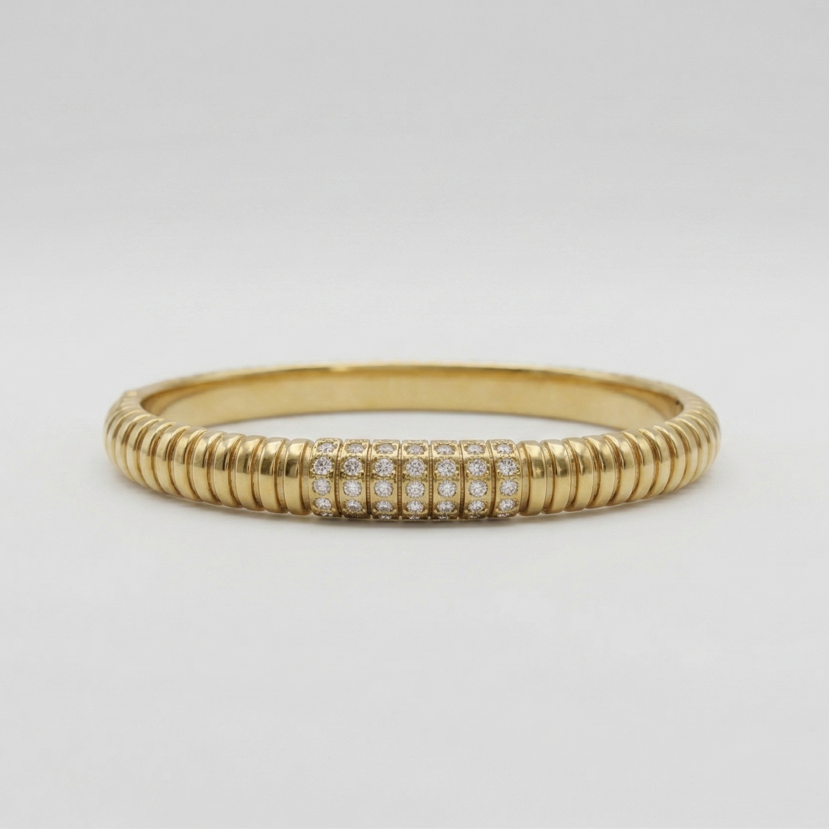 Gold ring with embedded diamonds on a light gray background