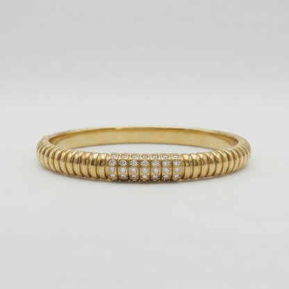 Gold ring with embedded diamonds on a light gray background