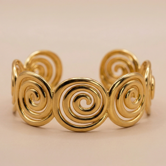 Gold spiral bracelet on a beige background