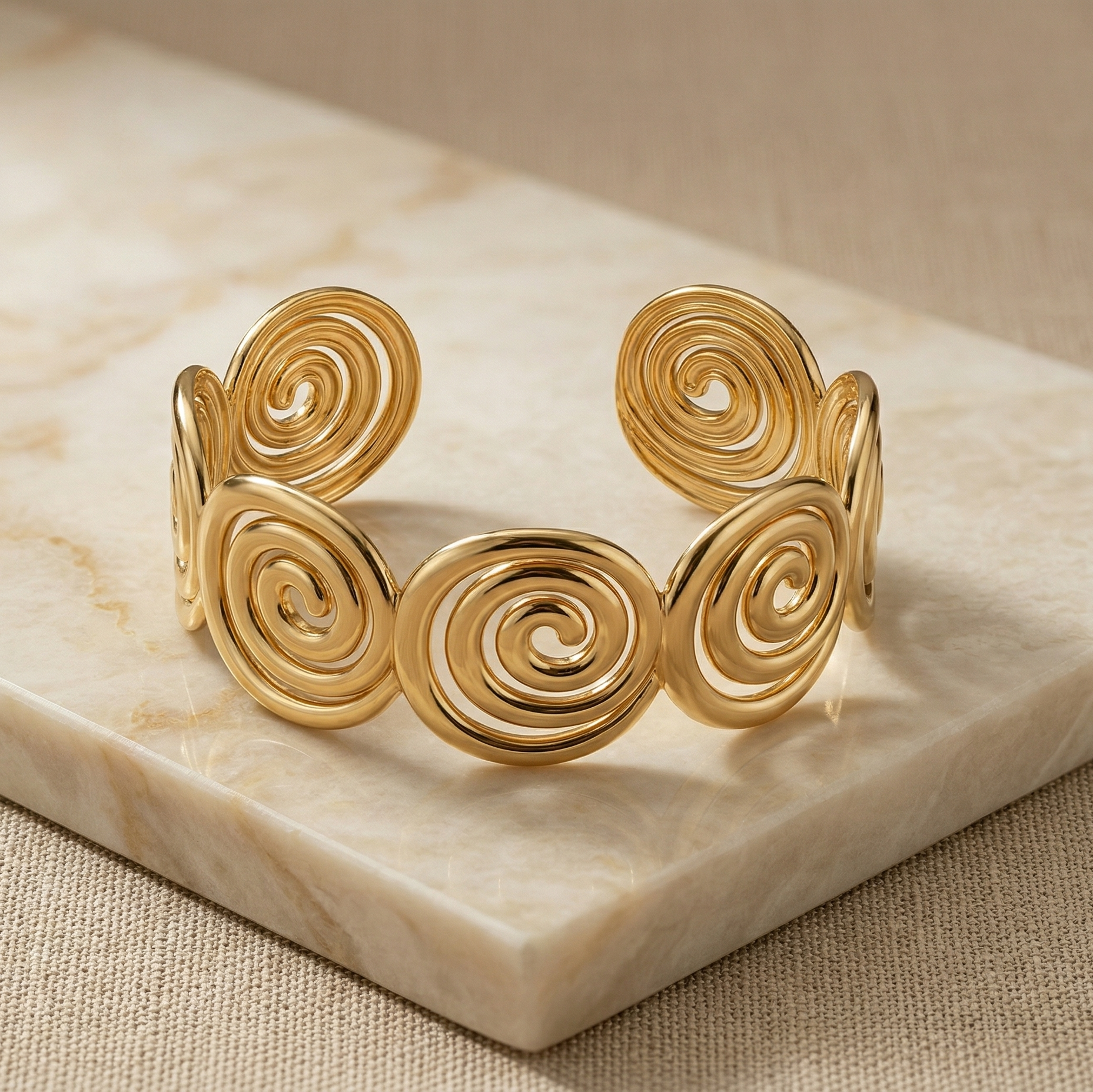 Gold spiral bracelet on a marble surface