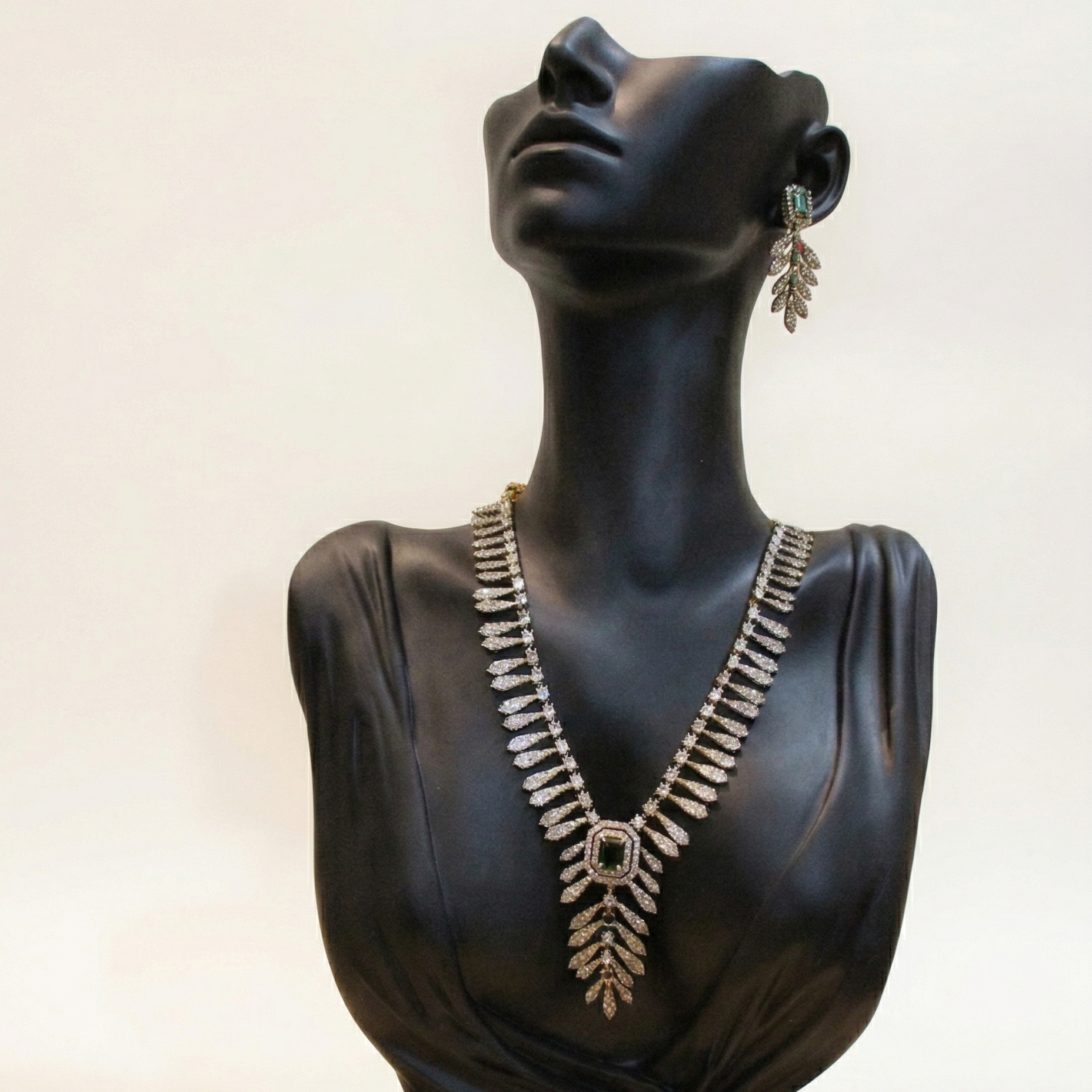 Mannequin bust wearing a necklace and earrings on a white background