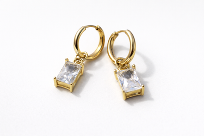 Gold hoop earrings with clear gemstones on a white background