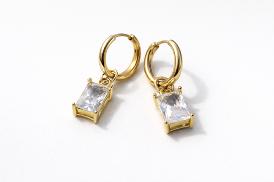 Gold hoop earrings with clear gemstones on a white background