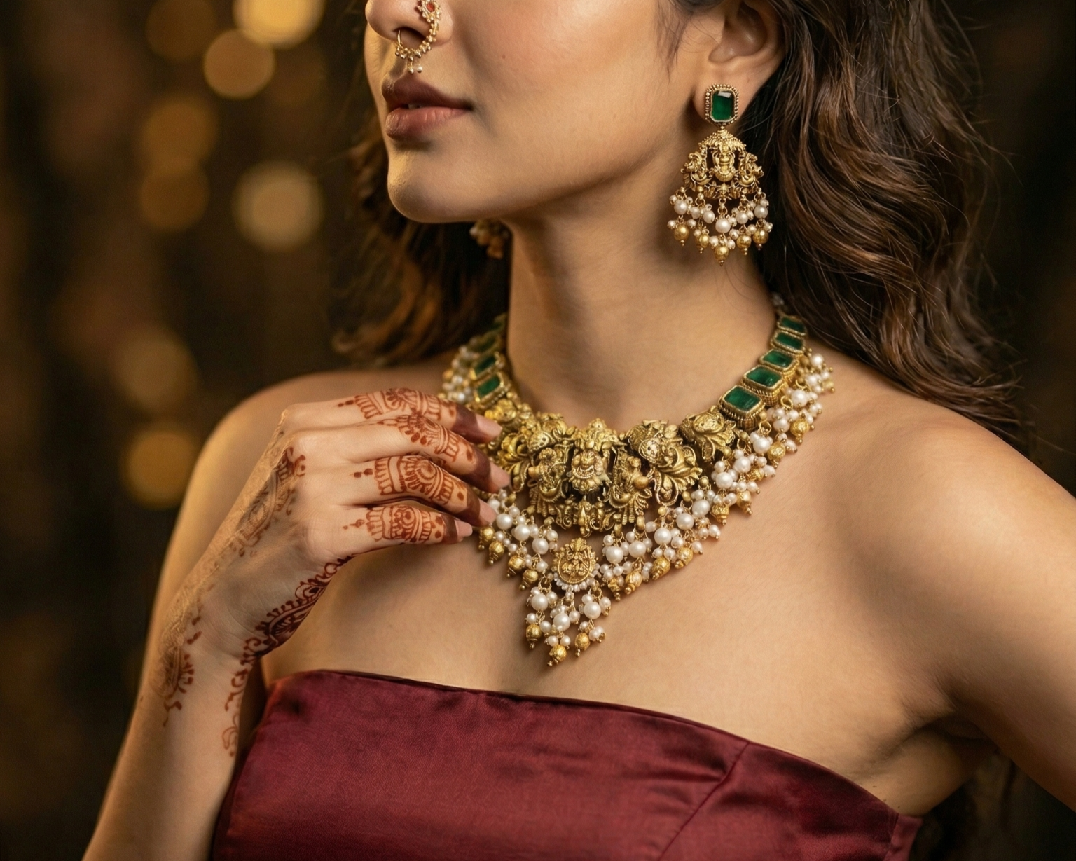 Woman wearing a gold necklace and earrings with a blurred background
